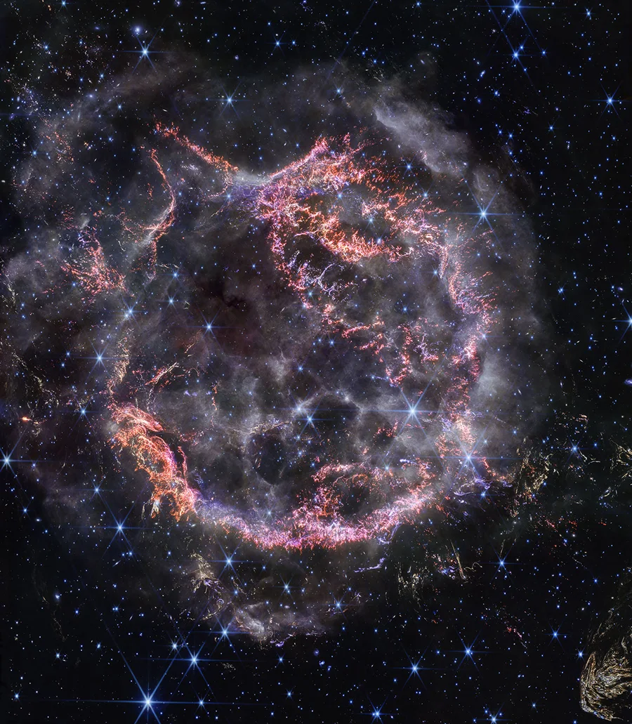 Glowing orange and pink filaments of Cassiopeia A, the remnant of an exploded star